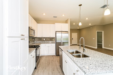 A kitchen with white cabinets and a granite countertop.