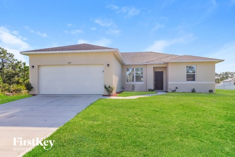 A house with a garage and a driveway in front of it.