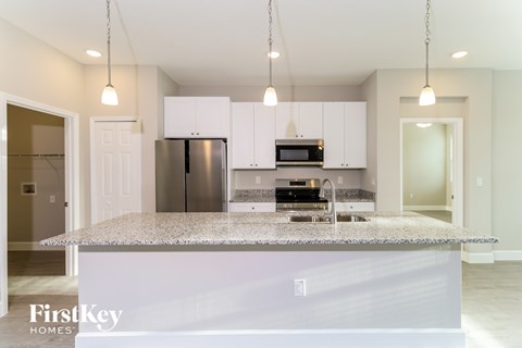 A kitchen with a granite countertop and stainless steel appliances.
