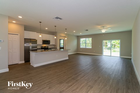 A spacious kitchen and living room with wooden floors and a large island.