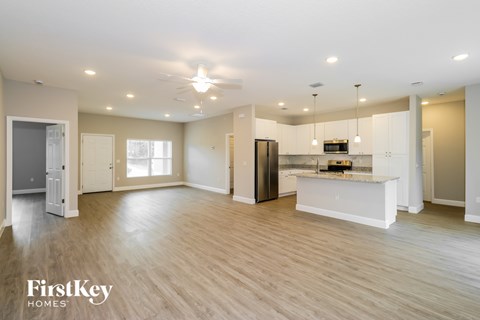 A spacious kitchen with a refrigerator, microwave, and a countertop with a sink.