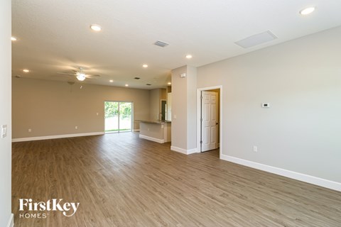 A spacious room with wooden flooring and a ceiling fan.