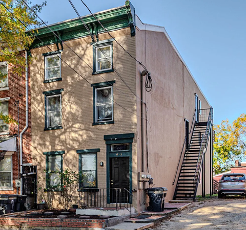 A brown building with a green door and windows.