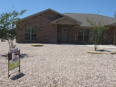 A house with a sign in front that says For Lease.