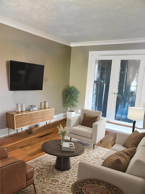 A living room with a brown leather chair and a white sofa.