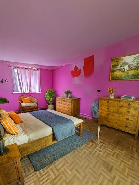 A bedroom with a bed, dresser, and nightstand.