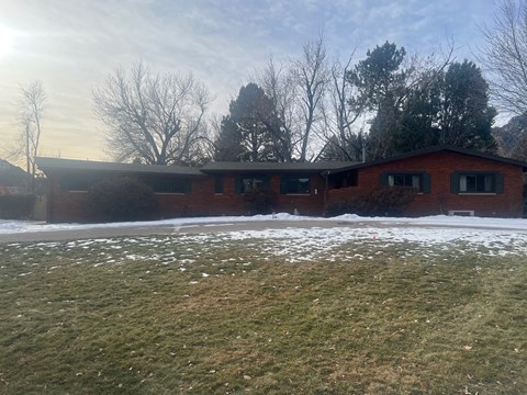 A red brick building with a snowy ground in front.