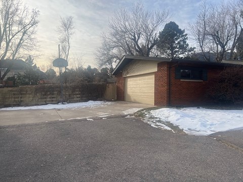 A residential area with a house and a basketball hoop.