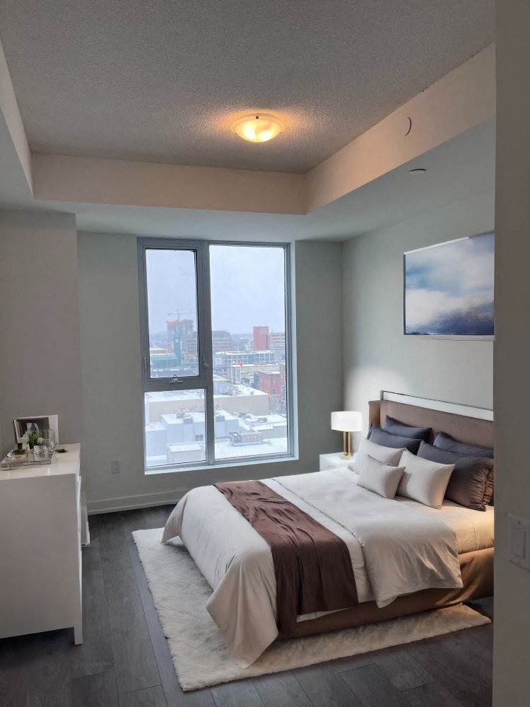 A bedroom with a large bed and a view of the city.