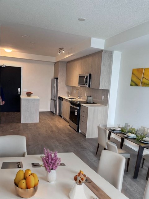 A modern kitchen with a dining table set for two.