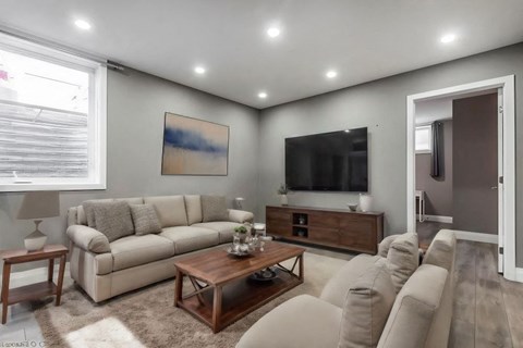 A living room with a large couch, a coffee table, and a painting on the wall.