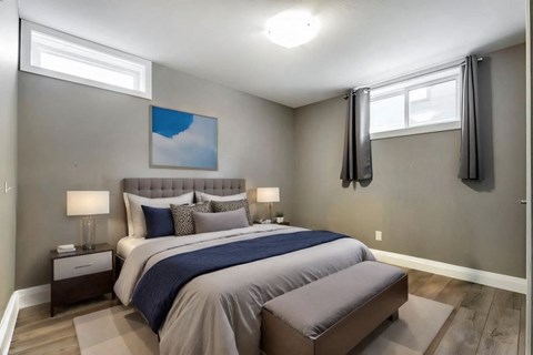 A bedroom with a large bed and a painting on the wall.