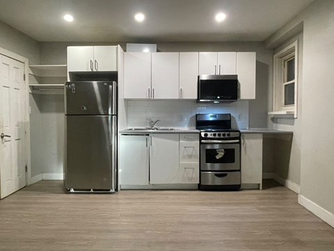 A kitchen with a stainless steel refrigerator, oven, and microwave.