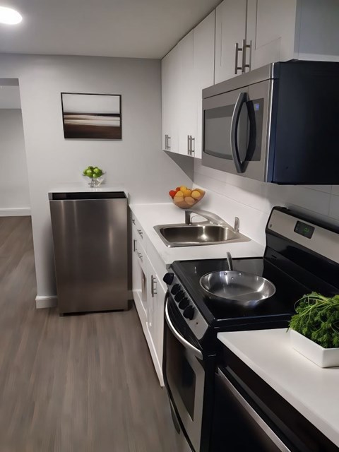 A modern kitchen with a stainless steel refrigerator, oven, and sink.
