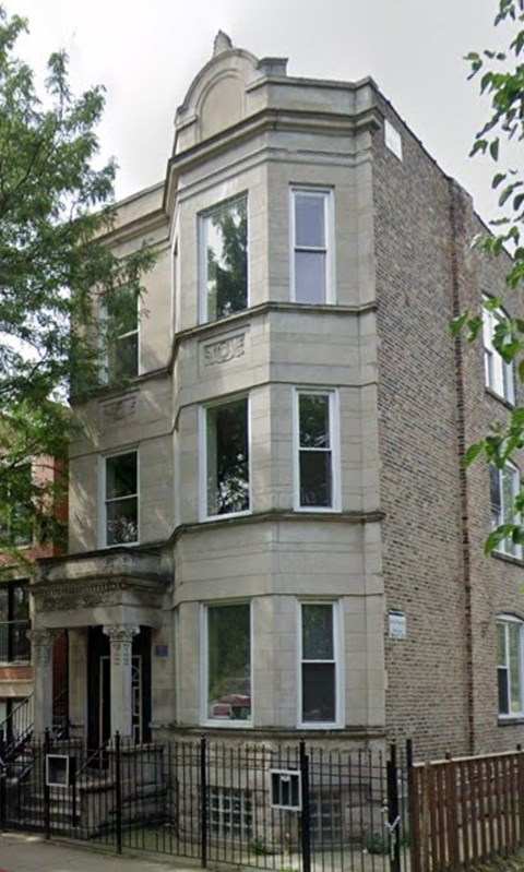 A large, old building with a black iron fence in front.