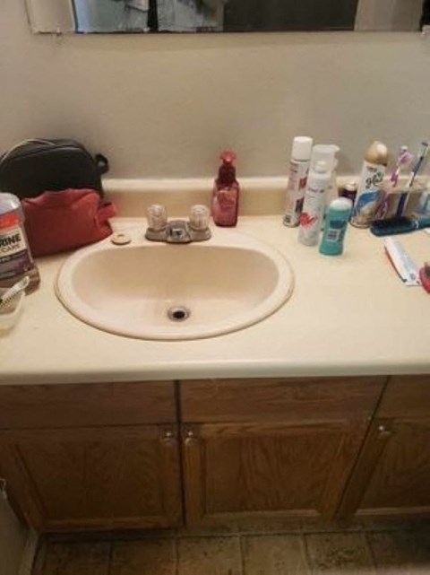 A bathroom sink with a red bag and various toiletries on the counter.