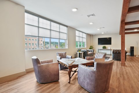A living room with brown chairs and a white table.