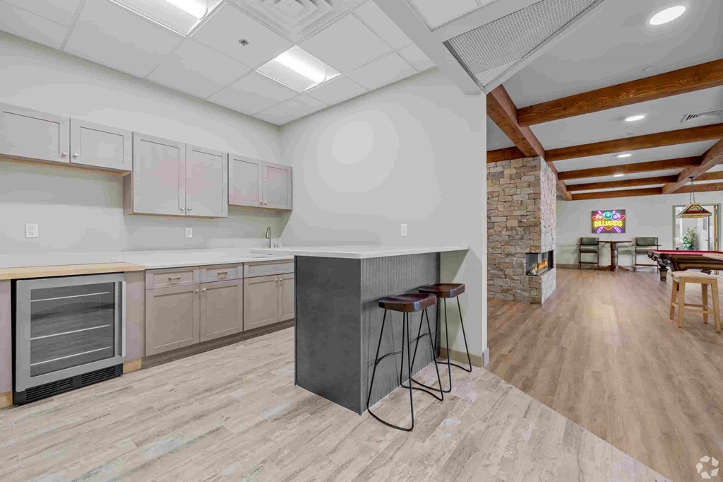 A kitchen with a brick wall and wooden floors.