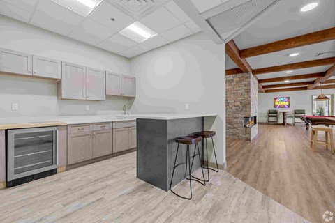 A kitchen with a brick wall and wooden floors.