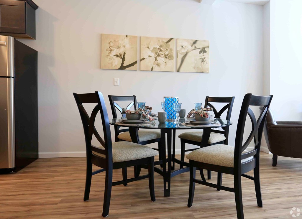 A dining table with four chairs around it.