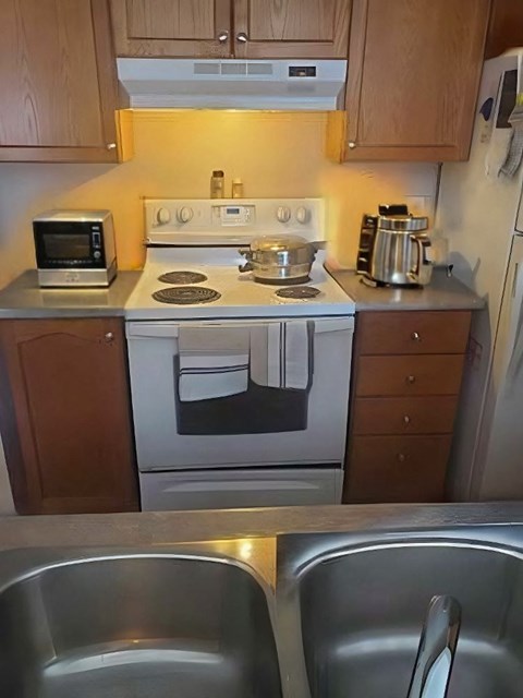 A small kitchen with a stove top oven and a microwave.
