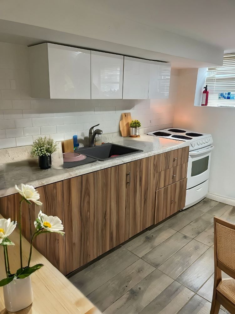 A kitchen with wooden cabinets and a white sink.