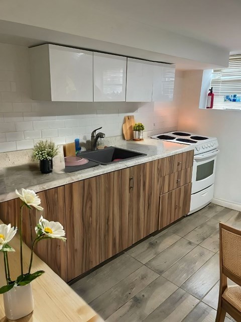 A kitchen with wooden cabinets and a white sink.