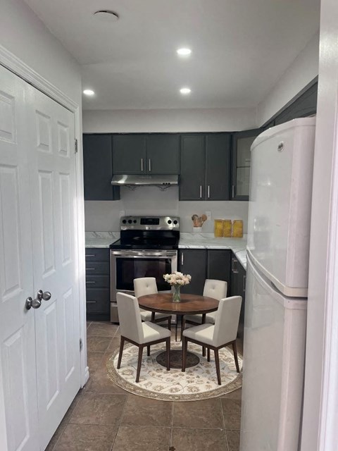 A kitchen with a table and chairs in the middle.