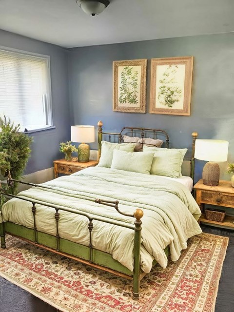A bed with a green metal frame and a white comforter is in the center of the image.