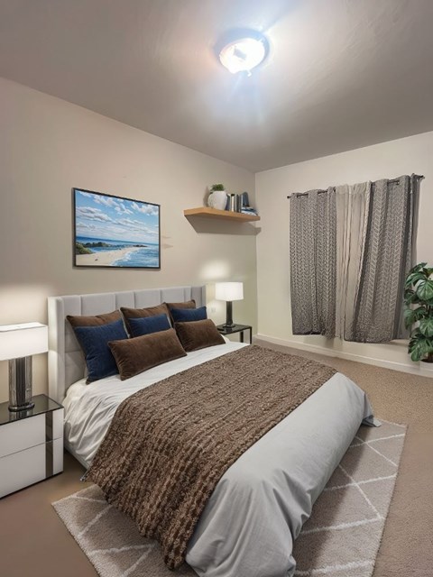 A bedroom with a large bed and a painting on the wall.