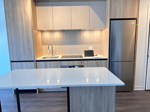 A modern kitchen with a table in the foreground.