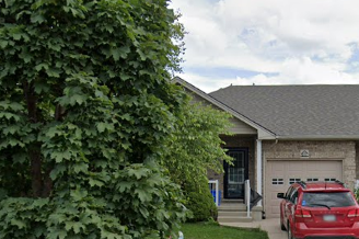 A red car is parked in front of a garage.