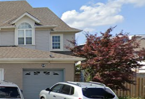 A house with a white car parked in front.