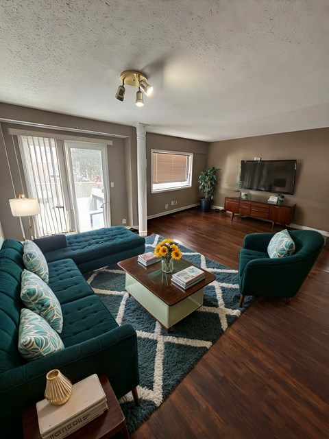 A living room with a green couch and a coffee table.