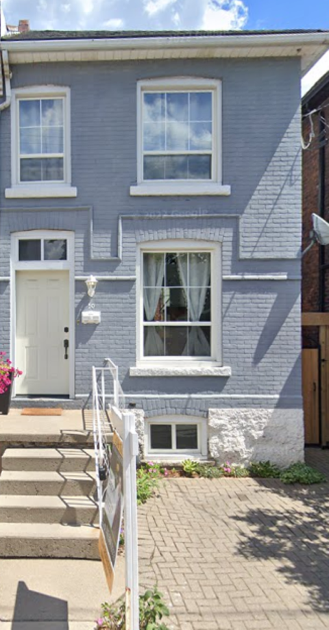 A grey house with a white door and windows.