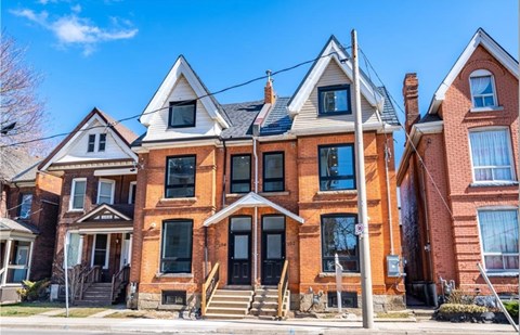 A row of houses with a blue sky in the background.