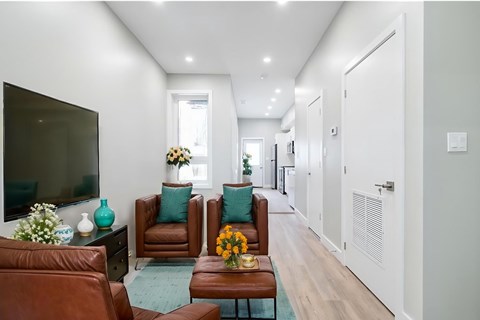 A living room with brown leather chairs and a flat screen TV.