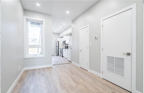 A kitchen with white cabinets and a window.