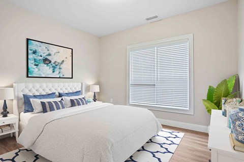 A bedroom with a large bed and a painting on the wall.