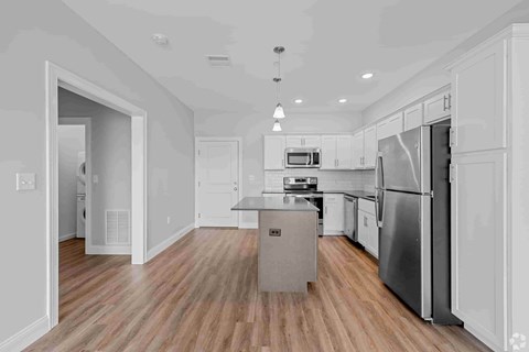 A modern kitchen with a refrigerator, microwave, and oven.