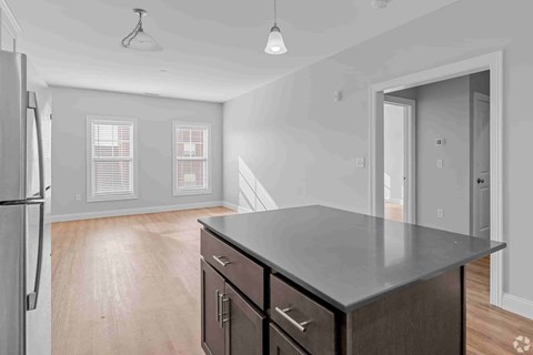 A kitchen with a refrigerator, cabinets, and a countertop.