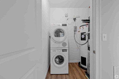 A laundry room with a washer and dryer stacked on top of each other.