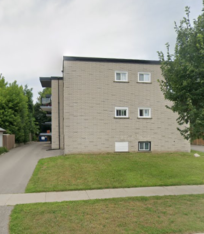 A grey building with a white door and windows.