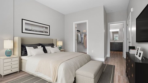 A bedroom with a large bed and a picture frame on the wall.