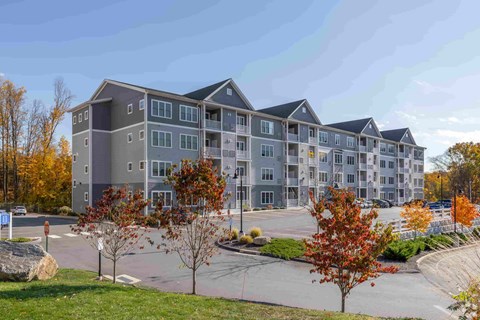 A large apartment complex with a parking lot in front.