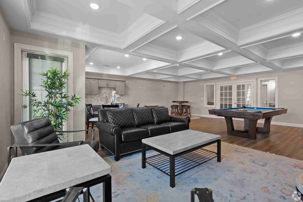 A living room with a pool table and a couch.