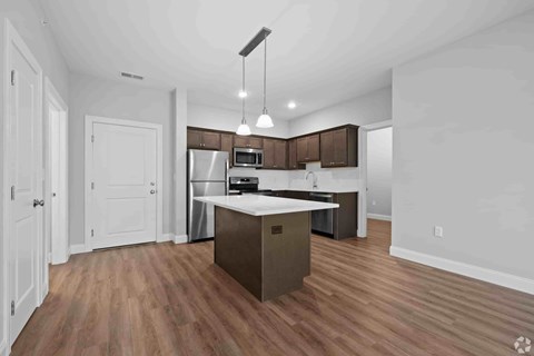 A kitchen with a white countertop and wooden floors.