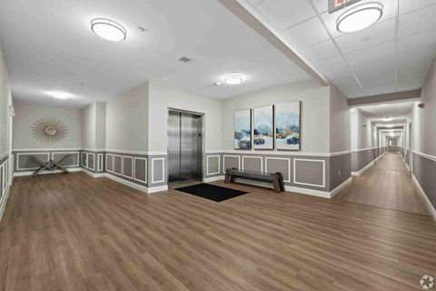 A hallway with wood flooring and a bench.