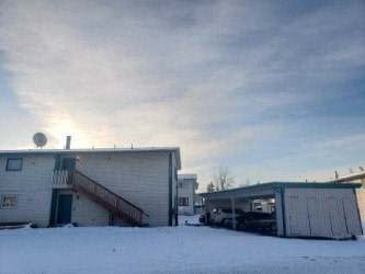 A building with a green roof is surrounded by snow.