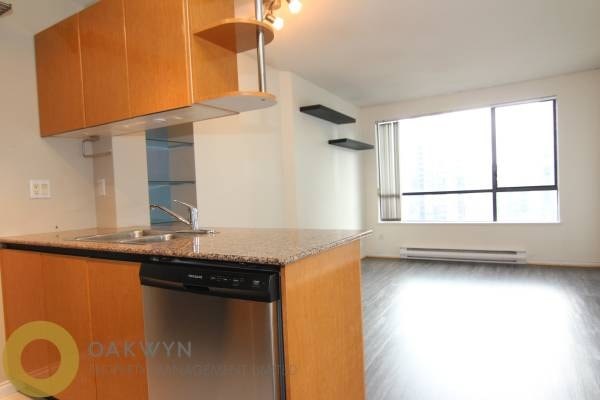 A kitchen with wooden cabinets and a black dishwasher.